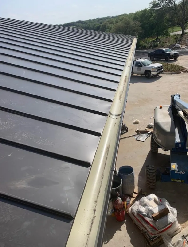 Standing seam panel and gutter detail on a metal roofing jobsite in Weddington
